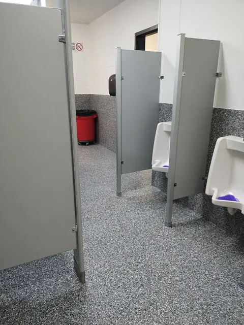 Quartz restroom floor around stall partitions and urinals