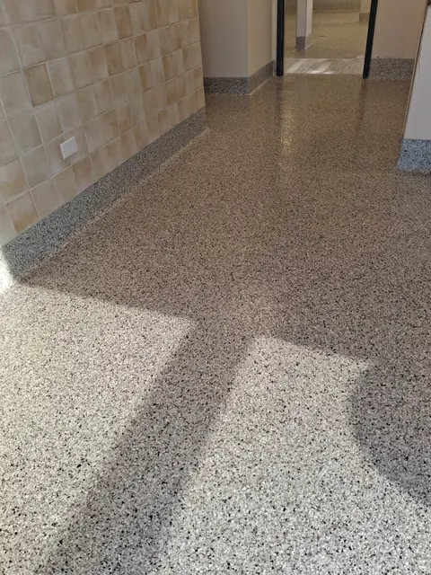 Quartz floor with integrated cove base along a tile wall